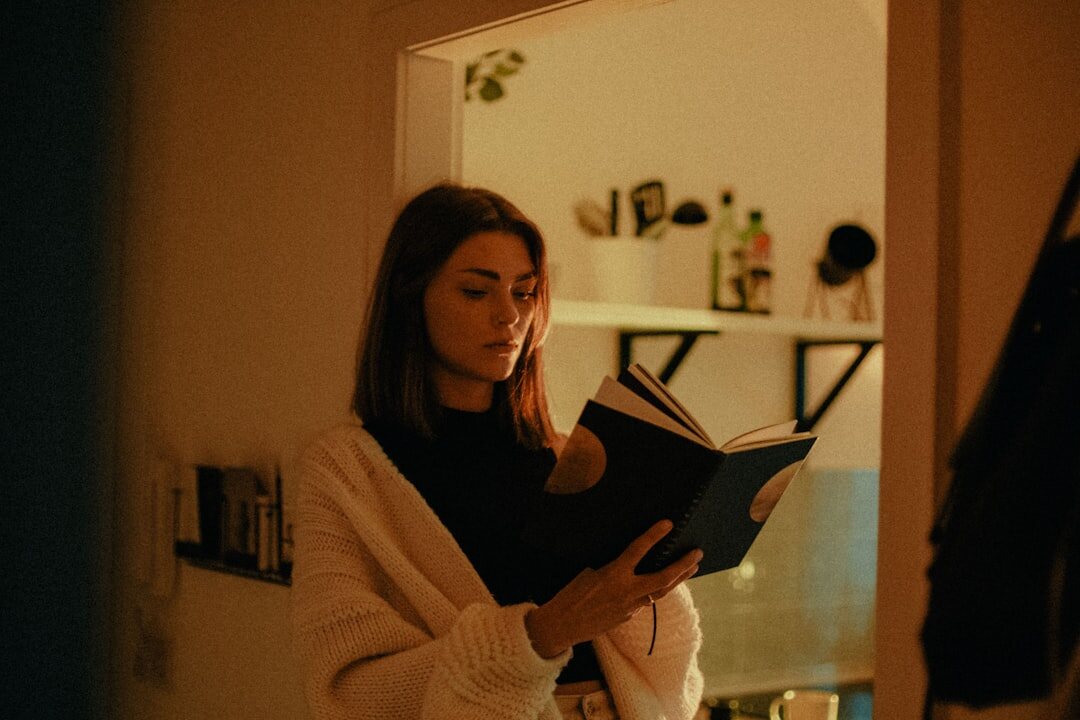 woman reading book at night